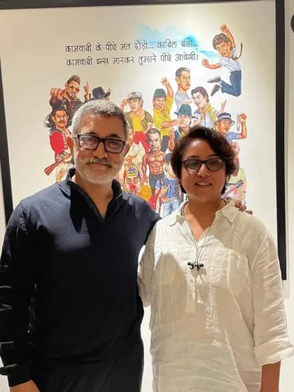 Aamir Khan and director Kiran Rao posing in front of the large wall poster I created for their office.