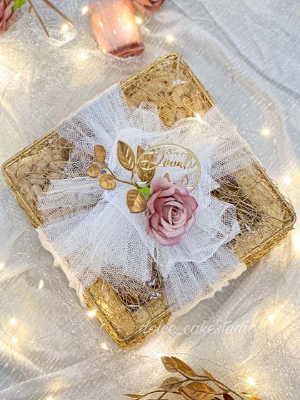 A top-down view of the mesh box hamper, beautifully wrapped with white tulle and a dusty rose accent. It’s a soft and elegant look for your Diwali gifting.