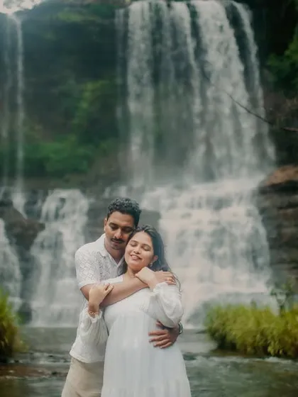 A gentle and loving embrace from behind, with the stunning waterfall creating a soft, misty backdrop. This portrait is full of warmth and romance.