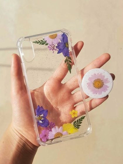 A matching set of a floral resin phone case and a pop-socket. The purple and yellow flowers create a lovely contrast, making your phone a true statement piece.