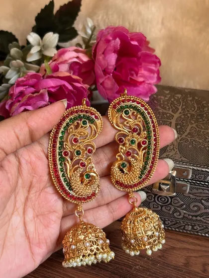 A clear still shot of the colourful peacock earrings.