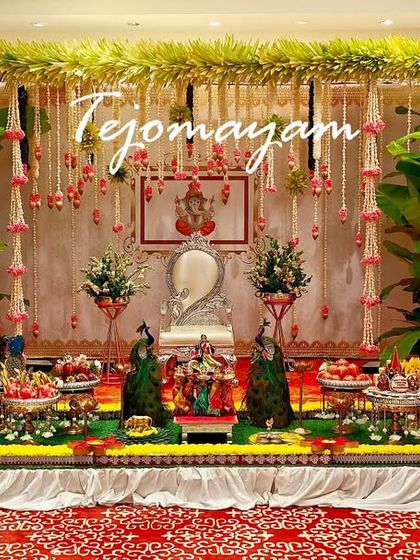 A half-saree ceremony featuring a backdrop of banana leaves and hanging floral strings. The silver Ganesha idol adds a touch of divine grace to the setup.