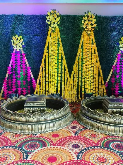 A traditional Haldi setup with large brass urlis and backdrops made of marigold and tuberose garlands, creating a classic and auspicious look.