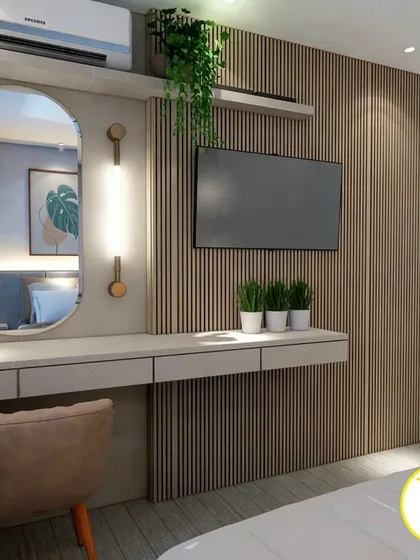 A functional and stylish corner in a bedroom, featuring a floating dressing table and TV unit against a fluted wood wall.