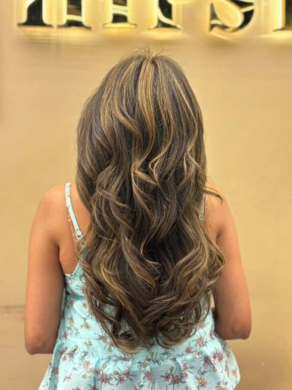 This back shot displays a full head of highlights that create a beautiful, multi-tonal effect. The colors are blended seamlessly for a natural yet impactful look.