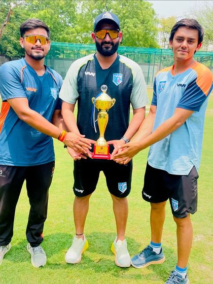 The coaching team with the trophy. We work as a team behind the scenes to ensure the players succeed on the field.