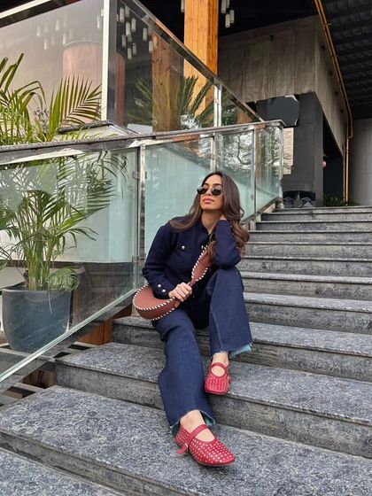 A full look featuring the red studded ballet flats and a whipstitch crossbody bag. This is a perfect example of mixing textures and details for a cohesive, stylish ensemble.