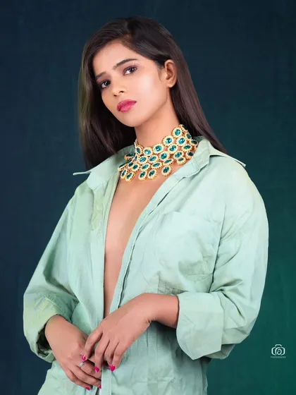 A modern way to style statement jewelry. The oversized necklace is paired with a simple, casually worn shirt, creating a high-fashion look that is both edgy and chic.