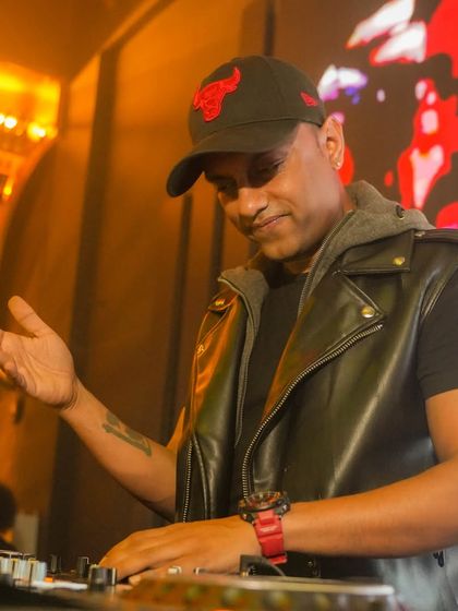 A shot of me in my element at Sugar Factory, wearing a leather vest and commanding the decks. It's all about the performance.