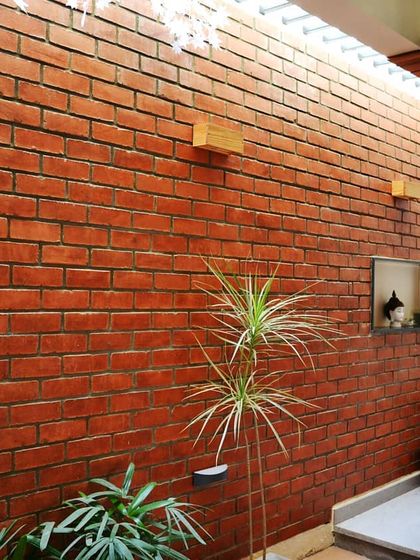 The atrium wall is made of exposed brick, creating a rustic and earthy feel. The skylight above ensures this central space is always bright and welcoming.