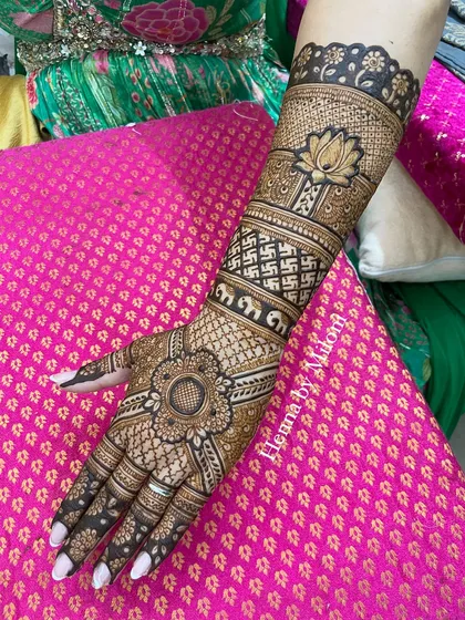 A stunning back-of-hand design with a central mandala. The arm features bands of elephants, swastikas, and lotus flowers for a rich, traditional look.