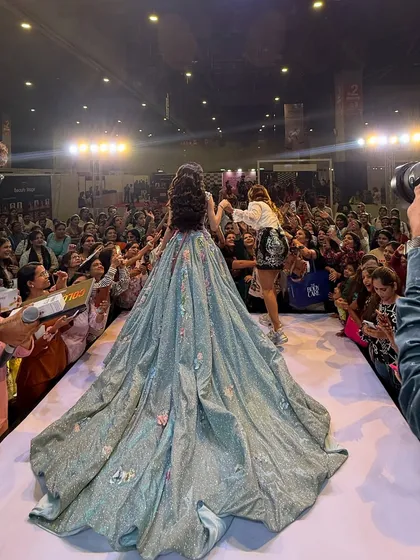 Adjusting the model's gown on the runway. A true artist takes care of the entire presentation, not just the makeup.