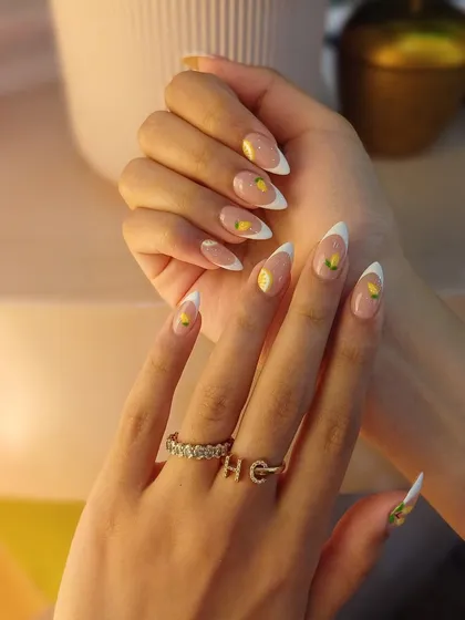 French tips, but make it zesty! This fun version features sharp white tips on almond extensions with cute, hand-painted lemons.