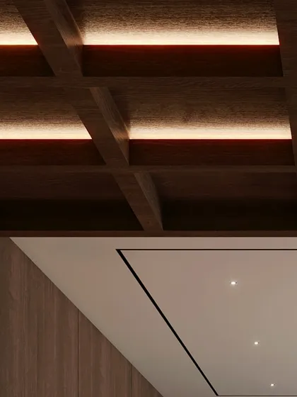A detail of the coffered wood ceiling with integrated lighting. The grounding color brown, with its cozy and warm qualities, is the perfect choice for a leisure or study space.