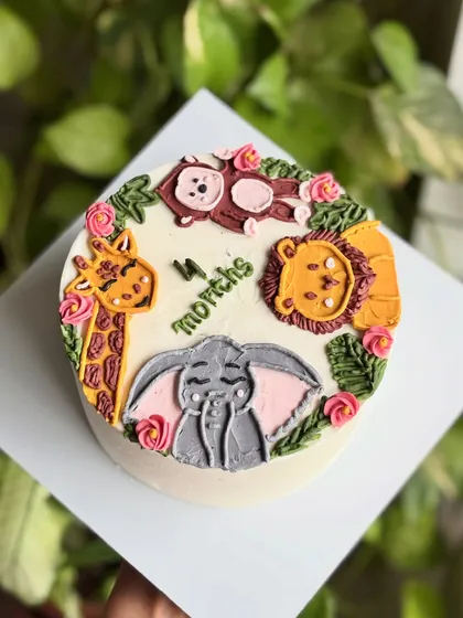 An overhead view of the jungle animal milestone cake, showing the cute arrangement of the piped characters.