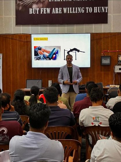 Presenting to boxing coaches at NSNIS Patiala. The banner in the back reads "Everyone wants to win, but few are willing to hunt," a motto that guides my work.