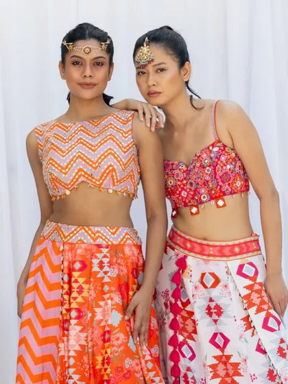 This image features two models to display different outfits from the same designer collection. The composition highlights the complementary nature of the pieces, perfect for showcasing the range and versatility of a line.