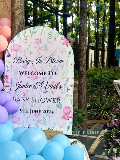 A personalized welcome sign for Janice and Vinil's 'Baby In Bloom' baby shower. The floral graphics and pastel balloon colors create a soft and inviting entrance for guests.
