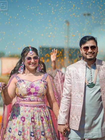 The pure, unadulterated joy of a wedding celebration. This shot captures the vibrant energy of a daytime Mehendi, with flower petals raining down on the happy couple. It’s about capturing the fun, the laughter, and the cool, modern vibe of your celebration.