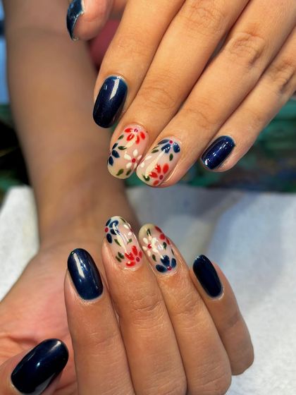 A beautiful combination of solid color and delicate art. This set pairs glossy navy blue nails with accent nails featuring a sheer base and a lovely red and blue floral pattern.