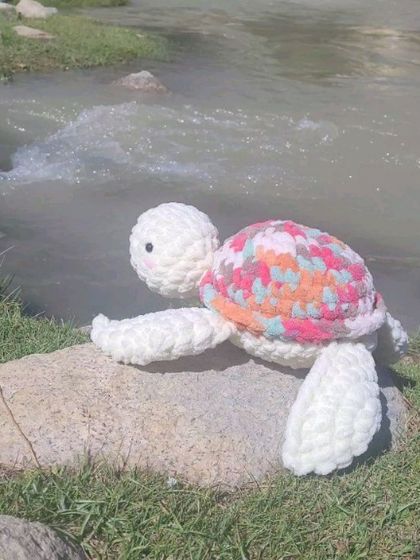 A peaceful shot of Olly the turtle resting on a rock by the water. The texture of the velvet yarn I use gives each plushie a wonderfully soft and squishy feel.