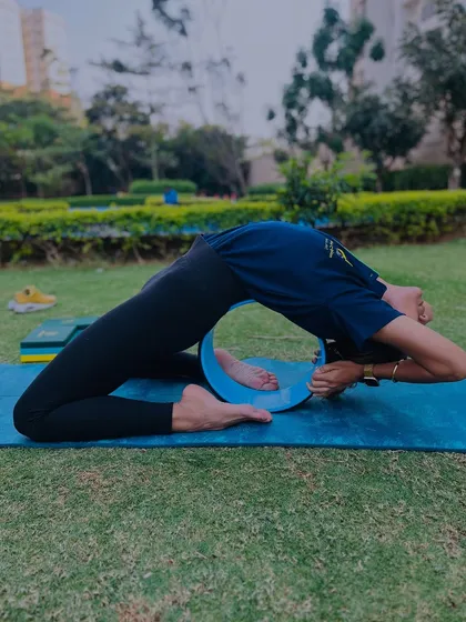 Using a yoga wheel to support a deep backbend. This allows for a passive opening of the spine and shoulders, making it a great preparatory and restorative tool.