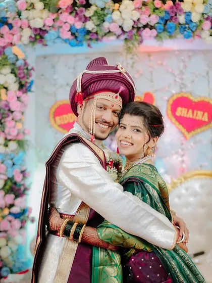 A beautiful portrait of a Maharashtrian couple, capturing their love and happiness. The bride is wearing a traditional green Nauvari saree with her makeup perfectly complementing the groom's attire.