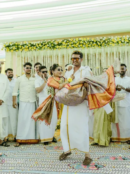 The groom joyfully carries his bride during their South Indian-themed Haldi ceremony in Pushkar.