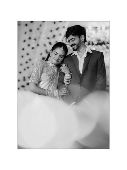 A tender black and white portrait of the couple, the bride resting her head on the groom's shoulder.