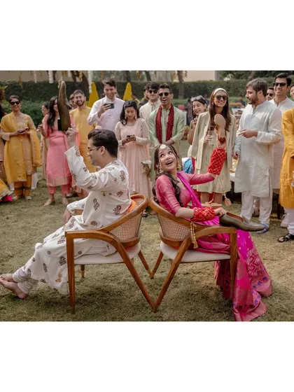 Saanya and Aayush play the shoe game during their mehendi, a fun and lighthearted way to see how well they know each other. Their laughter and the involvement of their guests make it a great moment.