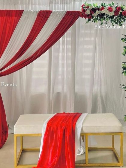 A bold red and white backdrop with a floral arch, perfect for making a statement at a birthday party, anniversary, or any other celebration.