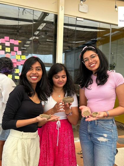 Three friends proudly show off the small pinch pots and trays they crafted during our beginner-friendly pottery workshop. It's a great activity to do with your tribe.