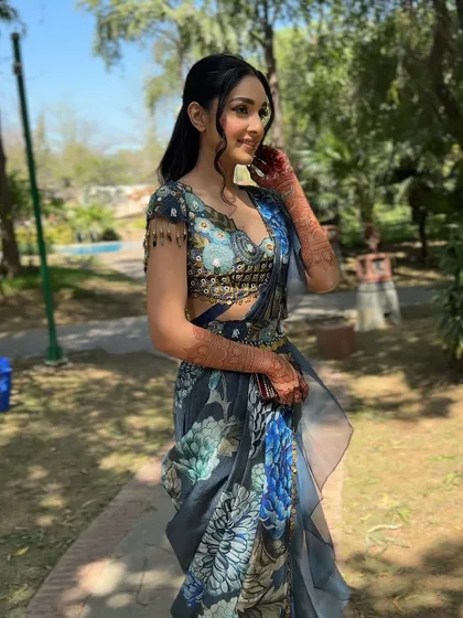 The full look in a beautiful outdoor setting. The blue floral saree and the fresh makeup create a look that is unique and stunning.