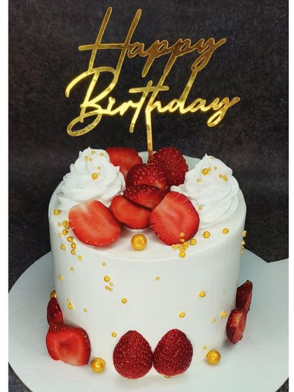 A simple and fresh seasonal strawberry cake. This tall cake is decorated with fresh strawberries and golden pearls for an elegant touch.