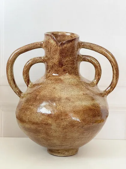 A large, hand-built vase with multiple handles, inspired by ancient pottery. The textured, rustic glaze gives it a timeless quality.
