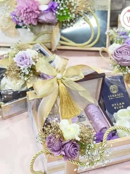 A collection of smaller gifts, each meticulously wrapped and decorated with purple and white florals. This shows our attention to detail across an entire gifting suite.