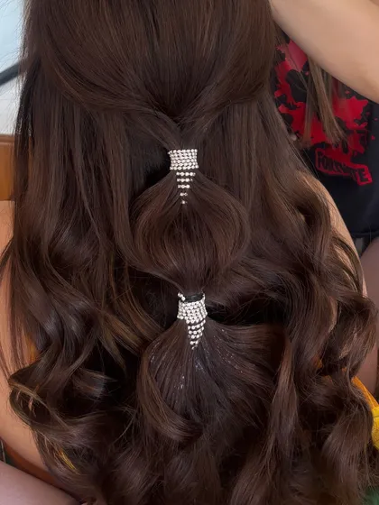 A close-up of the sparkling rhinestone cuffs on the half-up style. It's all about the details!