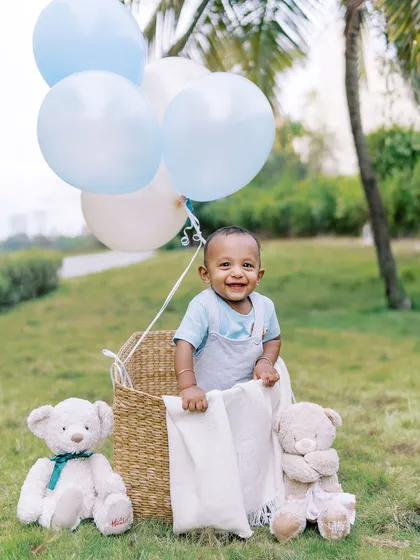 A joyful shot of the birthday boy in the basket prop, surrounded by teddy bears. These postcard-perfect photos are always a hit.