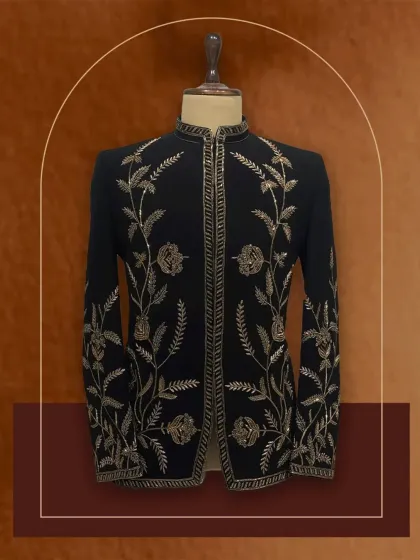 A studio shot of a black Jodhpuri jacket with intricate silver leaf and vine embroidery.
