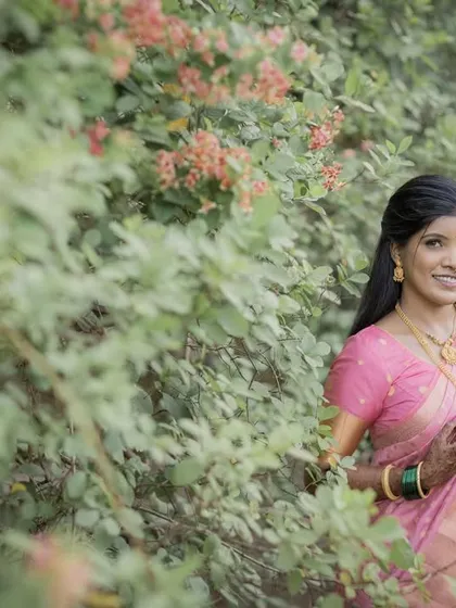 A beautiful portrait of the bride-to-be in a pink saree, set against a soft, natural background.