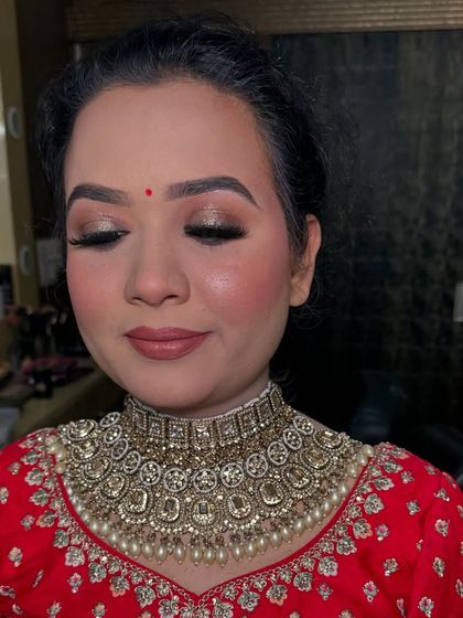 A close-up of a beautiful party look. The shimmery gold eyeshadow and nude lip are a classic combination for any festive occasion.