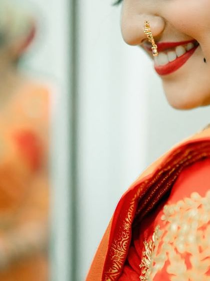 A candid close up of a bride's smile, reflected in a mirror. A creative and happy shot capturing her getting ready.