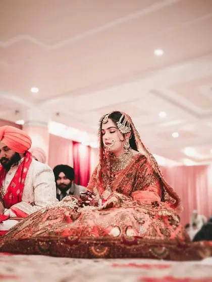 A low-angle shot of the couple during the Anand Karaj ceremony, creating an intimate and respectful perspective.