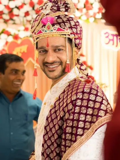 The groom's smiling face as he awaits the revealing of his bride during the Antarpat ceremony. Our photographers capture both perspectives of this beautiful tradition.