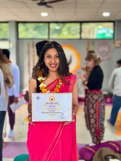 Holding my 200-hour Yoga Teacher Training certificate. This journey deepened my own practice and allows me to authentically guide the breathwork and meditation sessions that are core to my creative retreats.