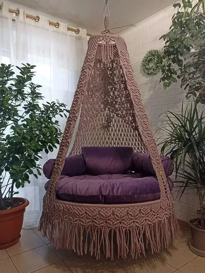 A beautiful brown single seater swing surrounded by indoor plants. It’s the perfect addition to create a green and serene corner in your home.