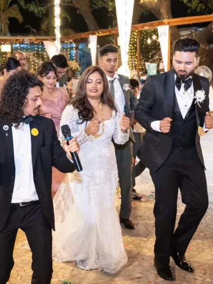 The emcee leads the bride and groom in a dance train, a classic and fun part of many Catholic wedding receptions in Mumbai.