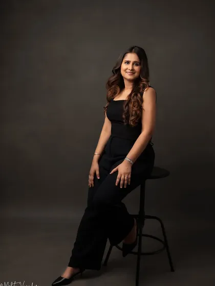 We used a classic dark backdrop for this full-length shot to create a powerful and elegant business portrait. The clean lines and confident pose make this a standout image for any professional profile.