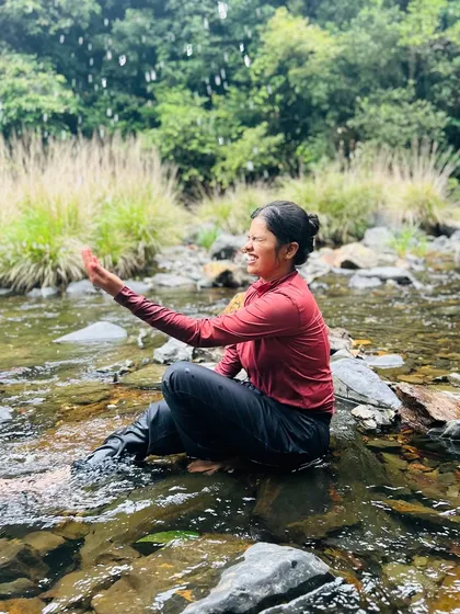 A trekker enjoying the rain and the cool water of a stream on the Kurinjal trek.