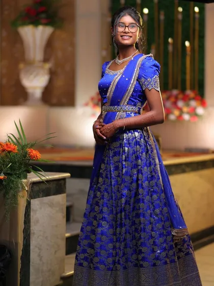 A young client looking beautiful in a royal blue brocade lehenga with puff sleeves, a design passed down through generations.